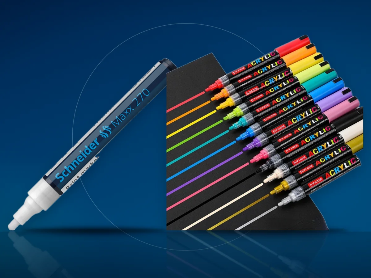 Un marker cu vopsea alba si un set de markere acrilice colorate, cu linii trase pe carton negru